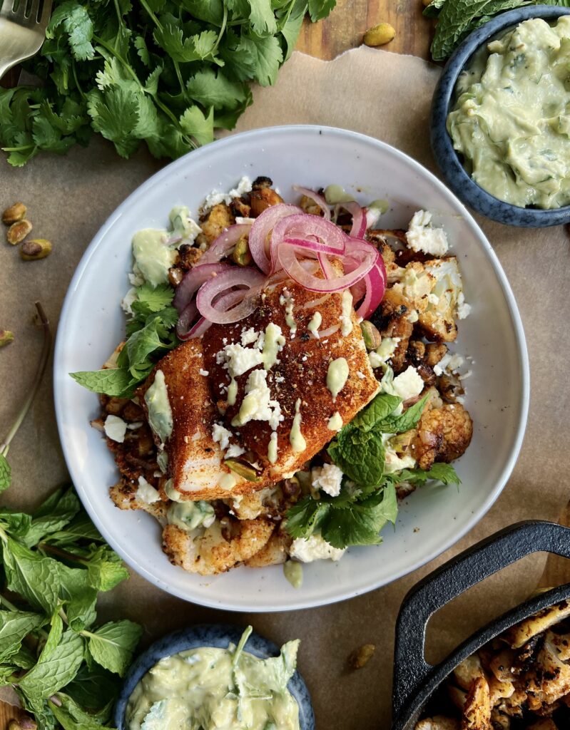 Crispy seared and roasted cauliflower florets tossed up in the most flavorful spice blend topped with flaky fish and a crunchy creamy avocado walnut herb blend: these Avocado Chimichurri Fish Taco Cauliflower Bowls truly are a burst of flavor!