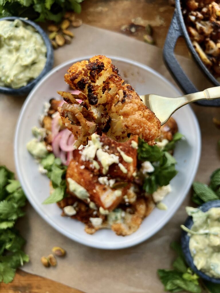 Crispy seared and roasted cauliflower florets tossed up in the most flavorful spice blend topped with flaky fish and a crunchy creamy avocado walnut herb blend: these Avocado Chimichurri Fish Taco Cauliflower Bowls truly are a burst of flavor!