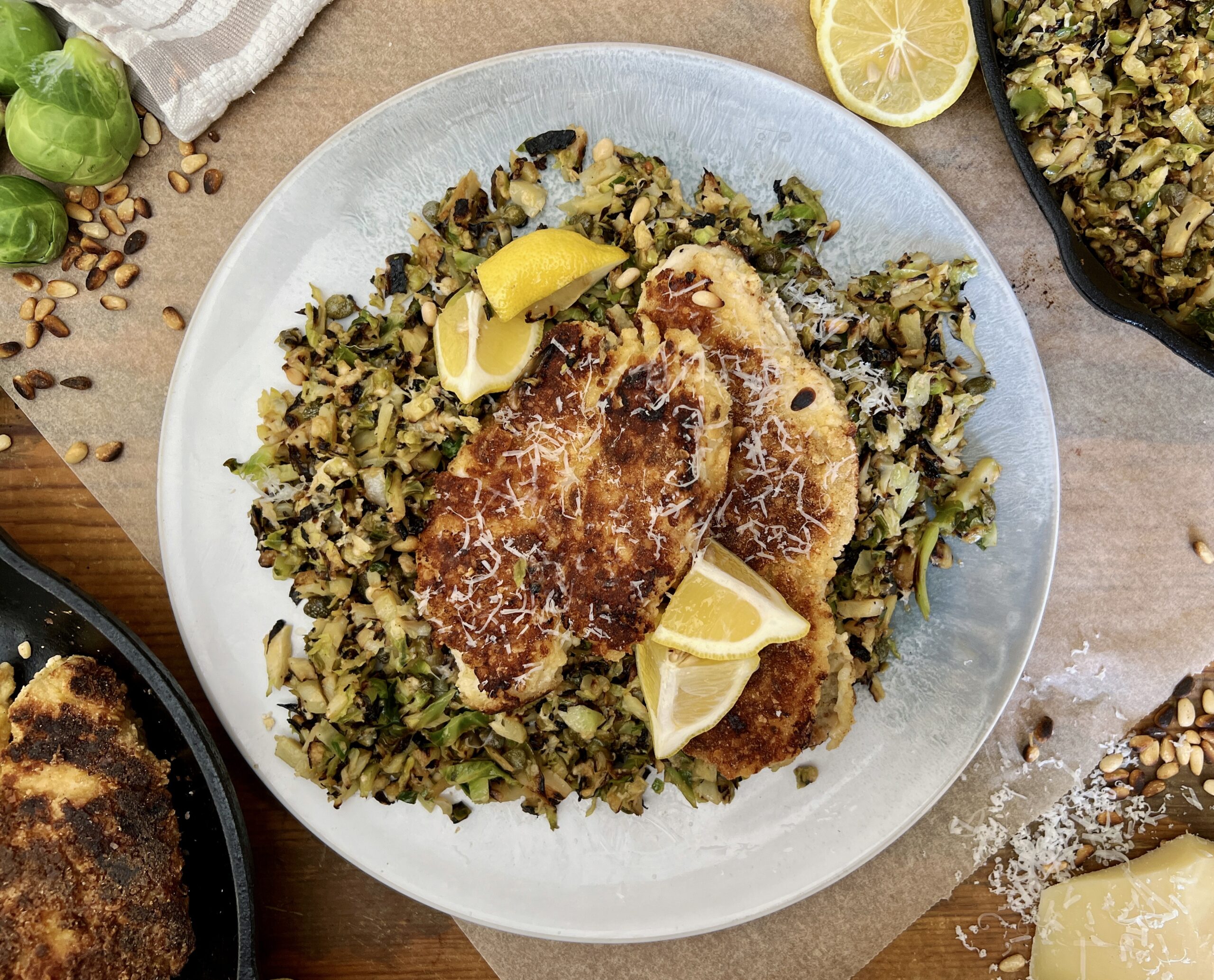 Juicy marinated, golden seared chicken on a simple parmesan briney brussels hash: this Crispy Chicken Over Lemon Caper Brussels is a burst of flavor!